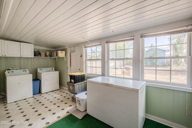 laundry area with wood ceiling, cabinets, and separate washer and dryer