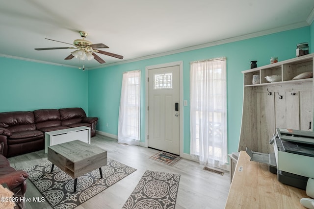 living room featuring ornamental molding, ceiling fan, and light wood-type flooring