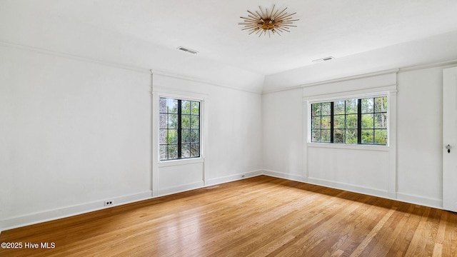 unfurnished room with hardwood / wood-style flooring and vaulted ceiling