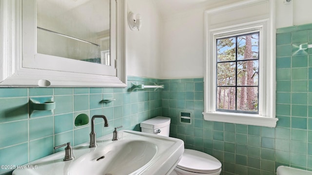 bathroom featuring sink, a wealth of natural light, tile walls, and toilet