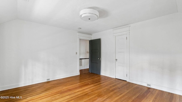 interior space featuring hardwood / wood-style flooring and vaulted ceiling