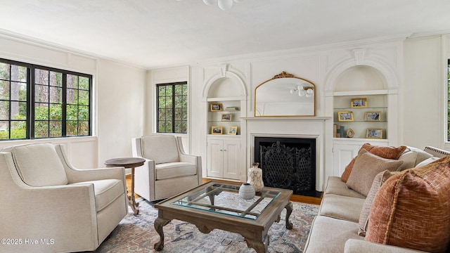 living room featuring hardwood / wood-style flooring, ornamental molding, and built in features