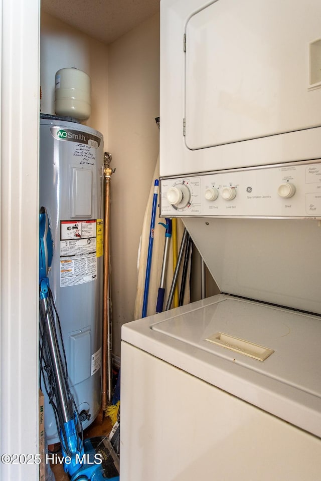 laundry area with stacked washer / drying machine and water heater