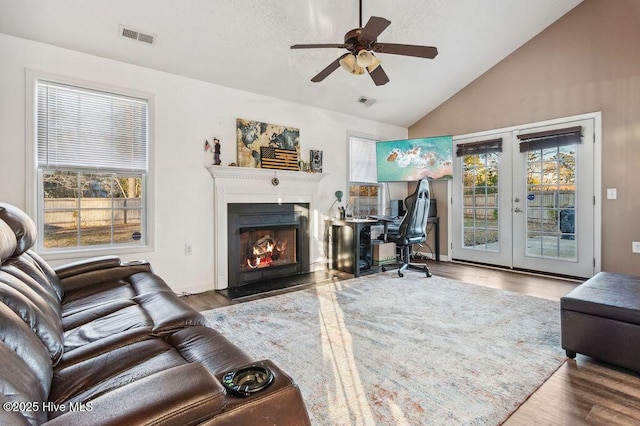 living room featuring hardwood / wood-style floors, vaulted ceiling, french doors, and ceiling fan