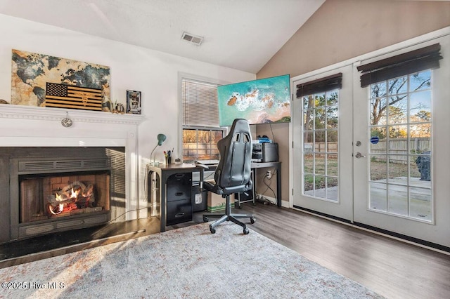 office space with lofted ceiling, hardwood / wood-style floors, and french doors