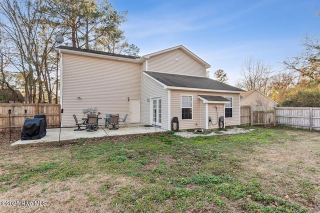 rear view of house with french doors, a yard, and a patio area