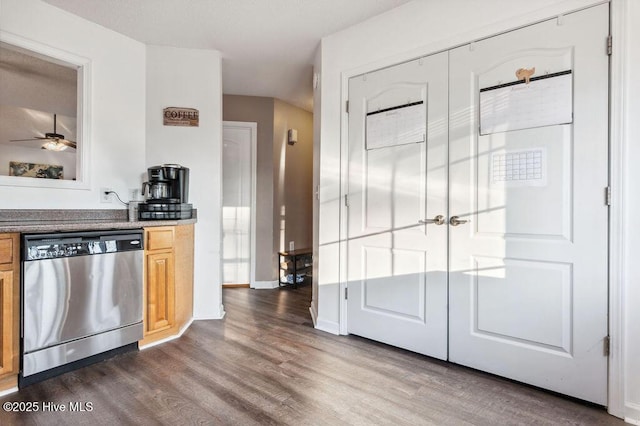 kitchen with dark wood-type flooring, stainless steel dishwasher, and light brown cabinetry