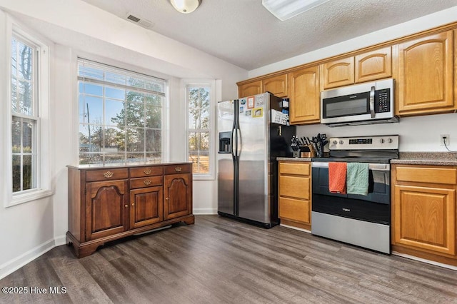 kitchen featuring stainless steel appliances, dark hardwood / wood-style floors, and a textured ceiling