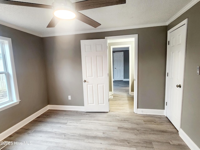 unfurnished bedroom featuring crown molding, a textured ceiling, ceiling fan, and light hardwood / wood-style floors