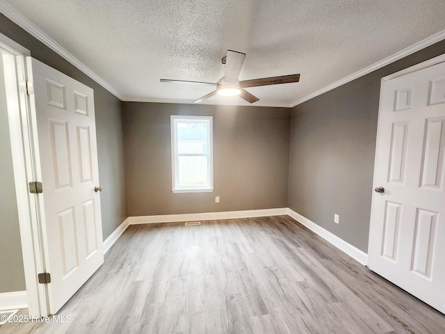 empty room with crown molding, ceiling fan, a textured ceiling, and light hardwood / wood-style flooring