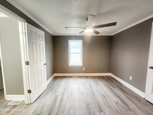 unfurnished room with ornamental molding, light wood-type flooring, ceiling fan, and a textured ceiling