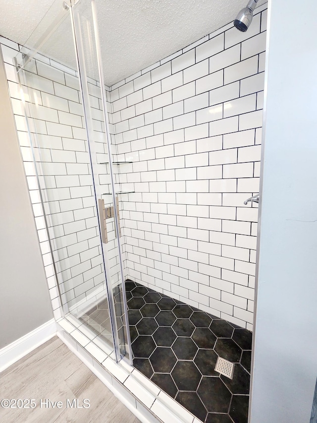 bathroom featuring a shower with door and a textured ceiling