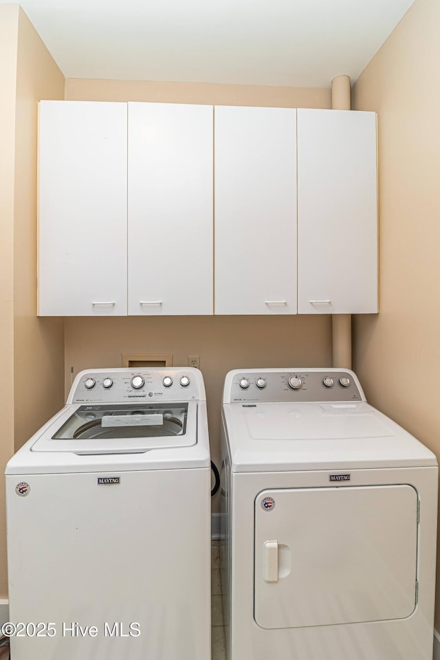 washroom with cabinets and washing machine and clothes dryer