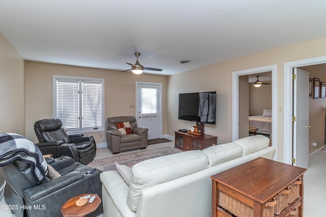 carpeted living room featuring ceiling fan