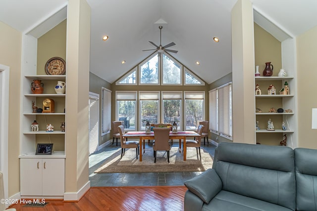 dining area featuring built in shelves, dark wood-type flooring, high vaulted ceiling, and ceiling fan