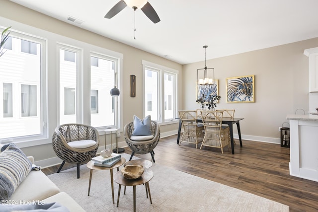 living room featuring a healthy amount of sunlight, dark hardwood / wood-style floors, and ceiling fan with notable chandelier