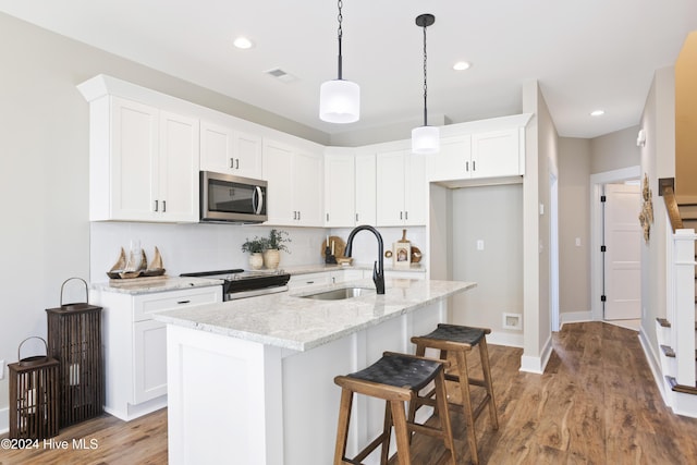 kitchen with electric stove, sink, light stone counters, and white cabinets