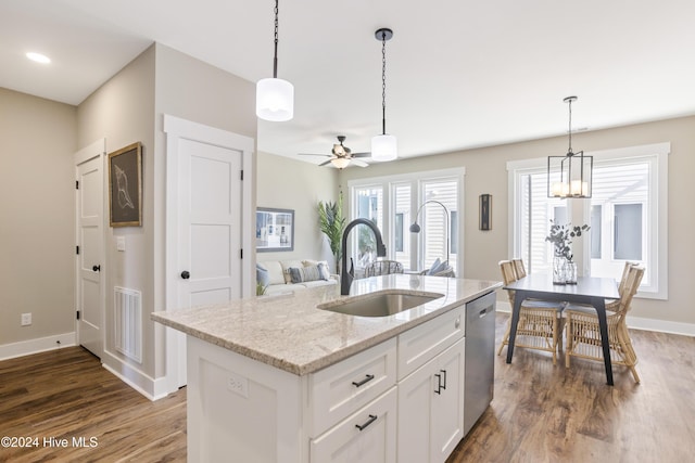 kitchen with dishwasher, sink, white cabinets, a kitchen island with sink, and light stone countertops