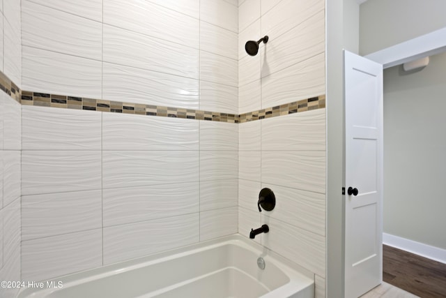 bathroom featuring tiled shower / bath and hardwood / wood-style floors