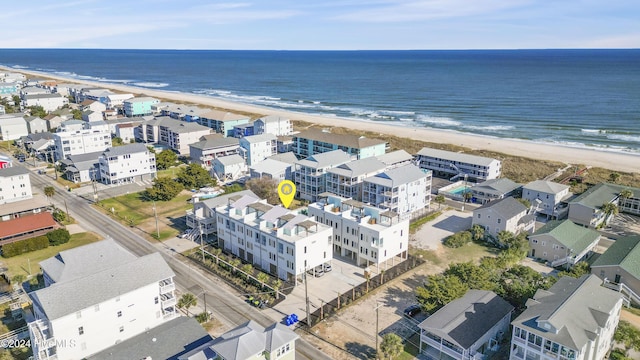 birds eye view of property featuring a water view and a beach view