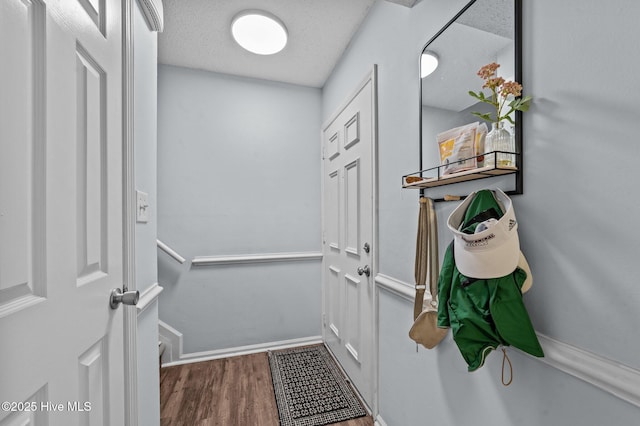 doorway featuring wood-type flooring and a textured ceiling