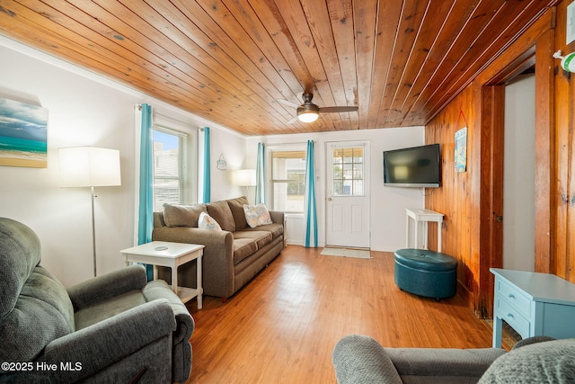 living room with wood ceiling, wooden walls, and light wood-type flooring