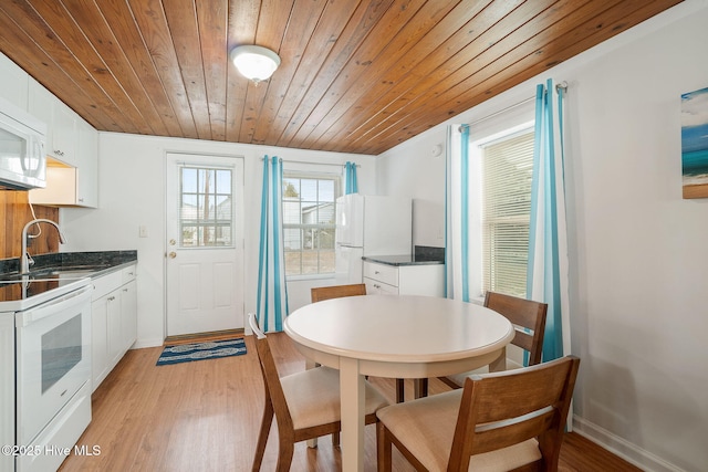 dining room featuring sink, wood ceiling, and light hardwood / wood-style flooring