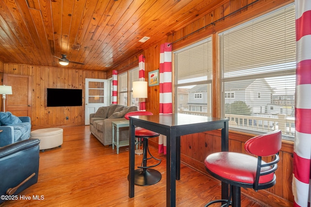 living room featuring wooden walls, wooden ceiling, and light hardwood / wood-style floors