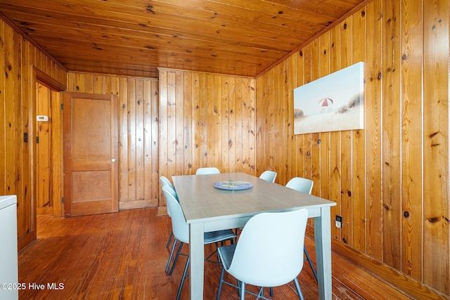 dining space with hardwood / wood-style flooring, wood ceiling, and wood walls