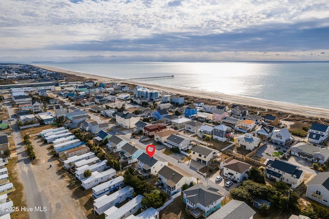 drone / aerial view featuring a water view and a view of the beach