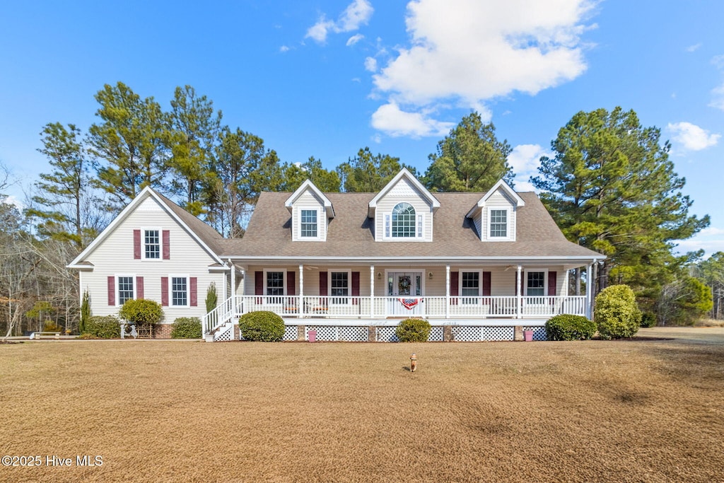 new england style home featuring a front yard and a porch