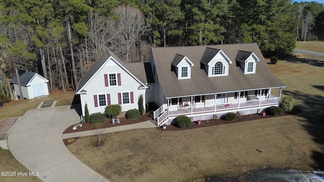 view of front of property featuring a porch, a storage shed, and a front yard