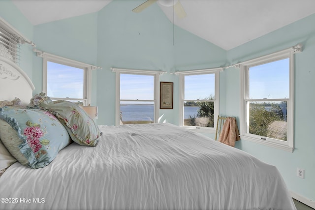 bedroom with lofted ceiling, multiple windows, ceiling fan, and a water view