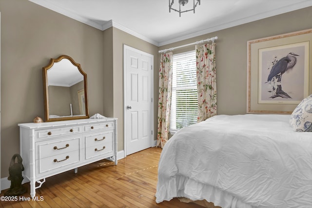 bedroom with ornamental molding and light hardwood / wood-style floors