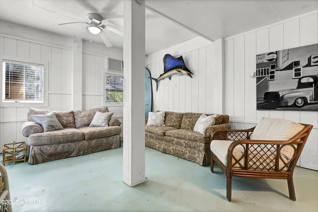 living room featuring ceiling fan and concrete flooring