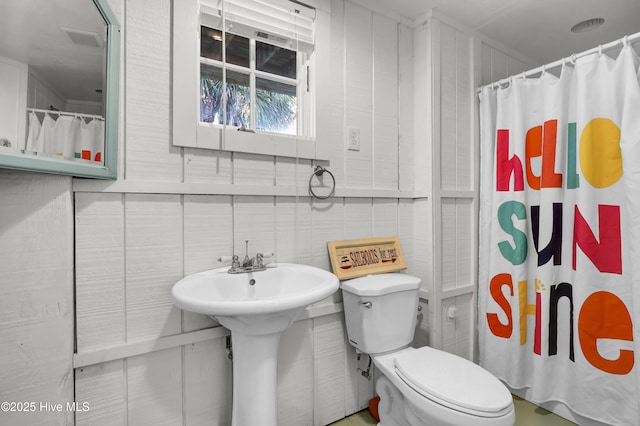 bathroom with toilet and a shower with shower curtain