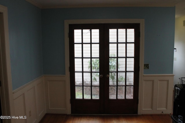 doorway with crown molding, light hardwood / wood-style floors, french doors, and a healthy amount of sunlight