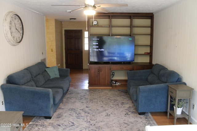 living room with hardwood / wood-style flooring, ceiling fan, and a textured ceiling