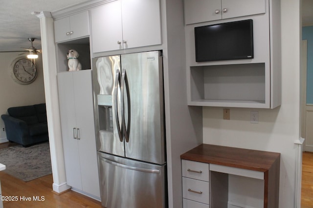 kitchen featuring light wood-type flooring, white cabinets, ceiling fan, stainless steel fridge with ice dispenser, and a textured ceiling