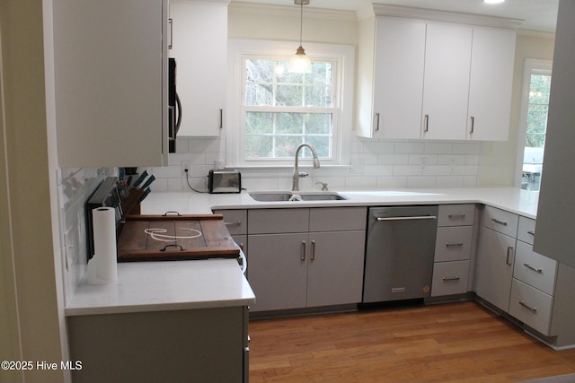 kitchen with pendant lighting, sink, gray cabinetry, white cabinets, and light wood-type flooring