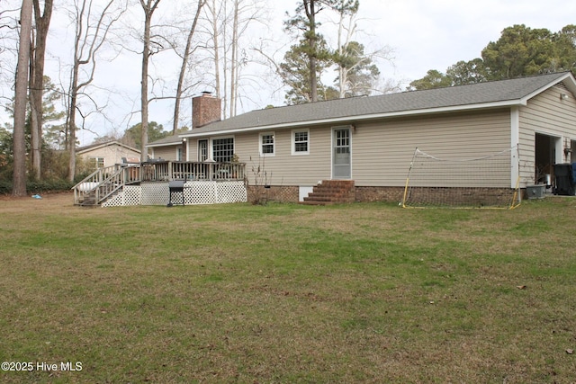 rear view of house with a wooden deck and a lawn