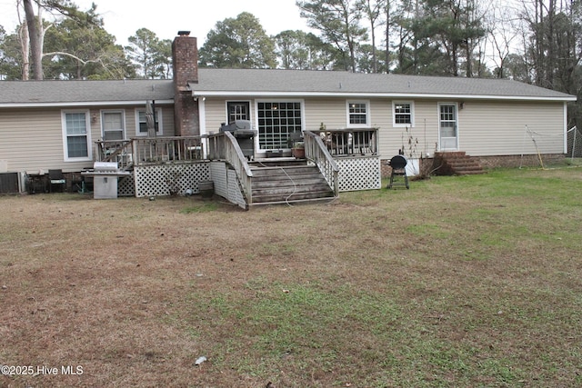 back of property with a wooden deck and a yard