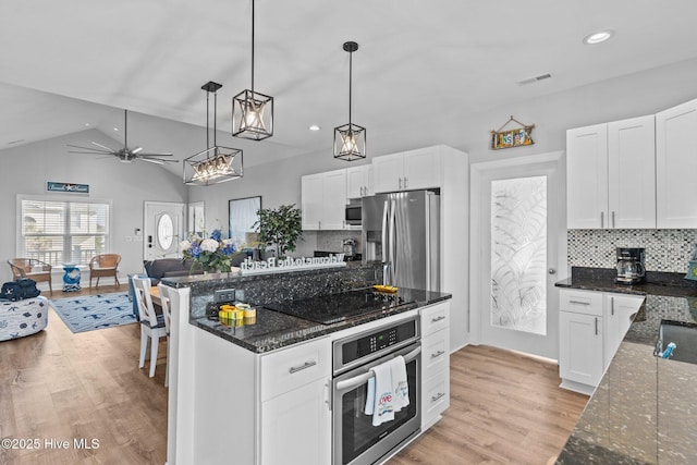 kitchen with dark stone countertops, stainless steel appliances, and white cabinets