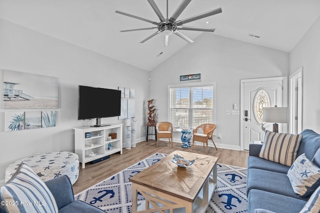 living room featuring hardwood / wood-style flooring, ceiling fan, and high vaulted ceiling