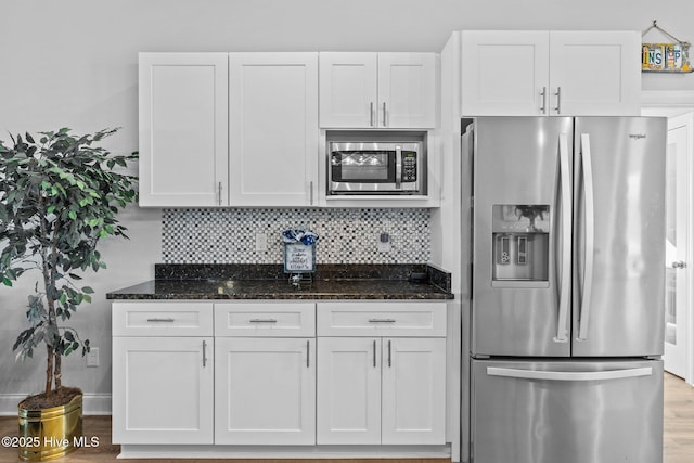 kitchen featuring white cabinetry, dark stone countertops, and appliances with stainless steel finishes