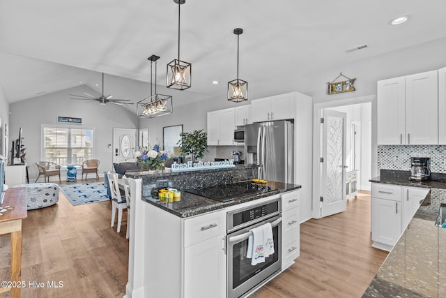 kitchen featuring pendant lighting, white cabinetry, stainless steel appliances, light hardwood / wood-style floors, and dark stone counters