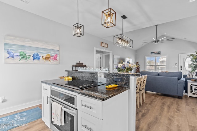 kitchen with white cabinetry, stainless steel oven, black electric cooktop, pendant lighting, and hardwood / wood-style floors