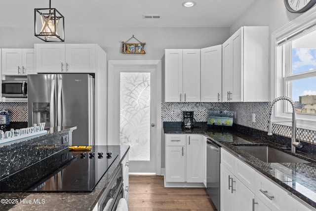 kitchen featuring white cabinetry, appliances with stainless steel finishes, sink, and pendant lighting