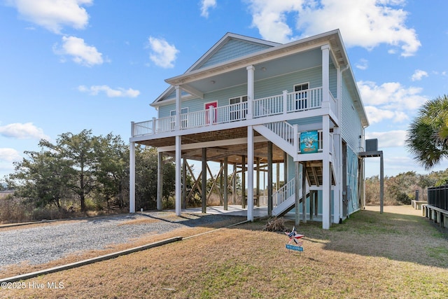 beach home featuring a porch, a carport, and a front yard