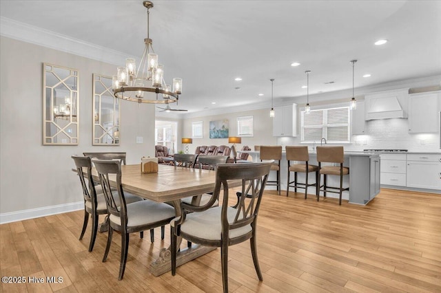 dining room featuring ornamental molding, sink, and light wood-type flooring